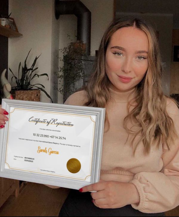 Young smiling woman presenting her name a star certificate of registration